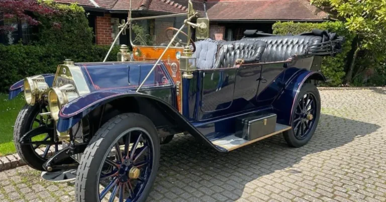 An old 1910 Buick which looks new, standing on a old stone street