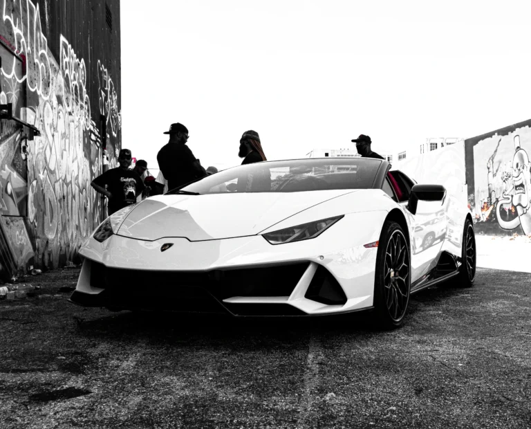 A white Lamborghini Huracan Evo standing between graffity walls
