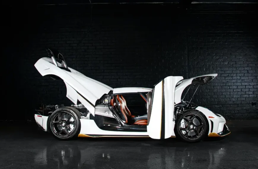 A white Koenigsegg Regera standing in a black box with all toors open