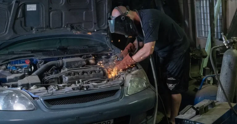 Mechanic works on an old Honda CIvic in his Garage