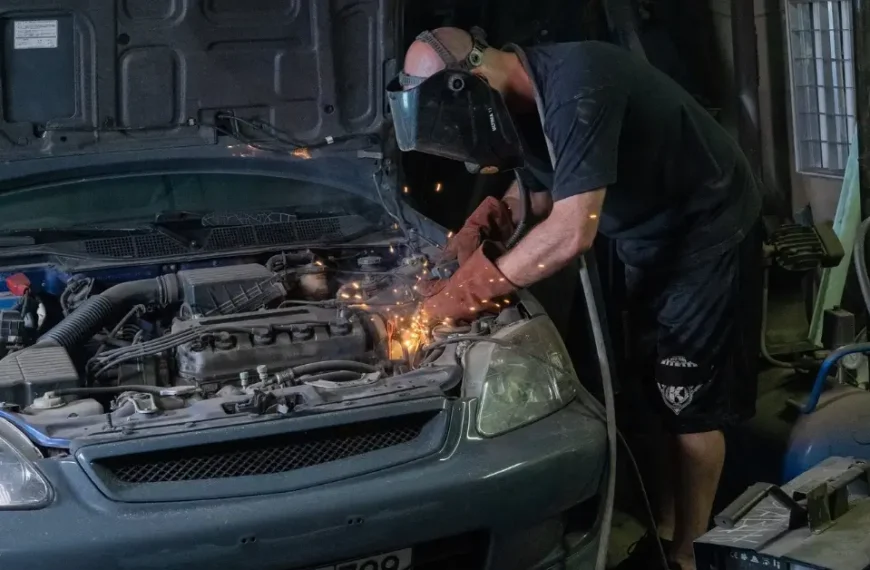 Mechanic works on an old Honda CIvic in his Garage