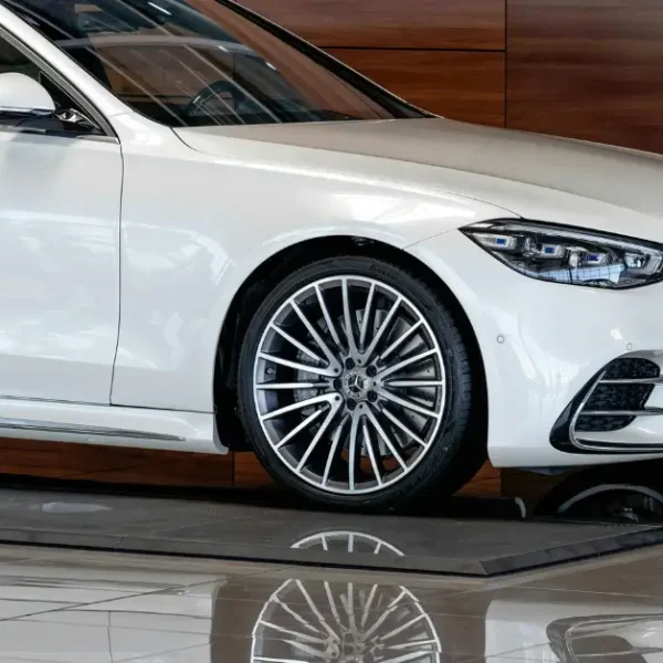 A white Mercedes S 500 in a showroom