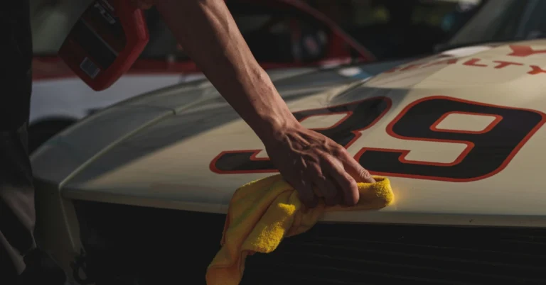 A Motorhood from a race car gets dried with a towel