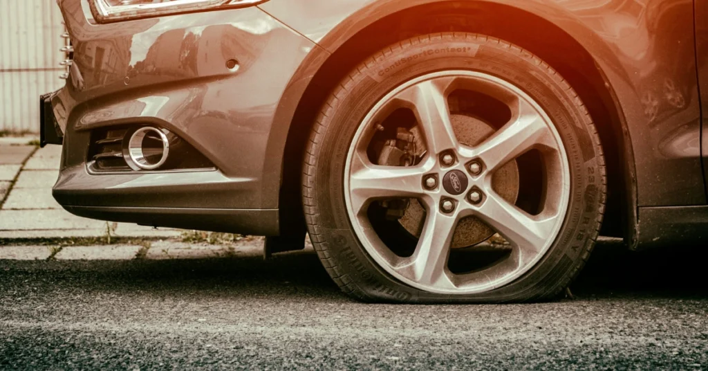 A flat Tire front left on a parked car