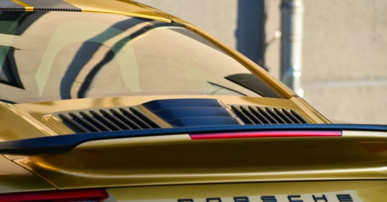 The tinted backwindow of a golden Porsche 911 Carrera