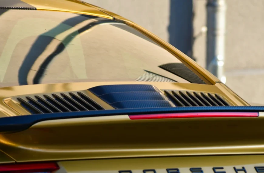 The tinted backwindow of a golden Porsche 911 Carrera