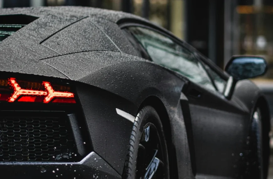 The back of a black Lamborghini driving on a street