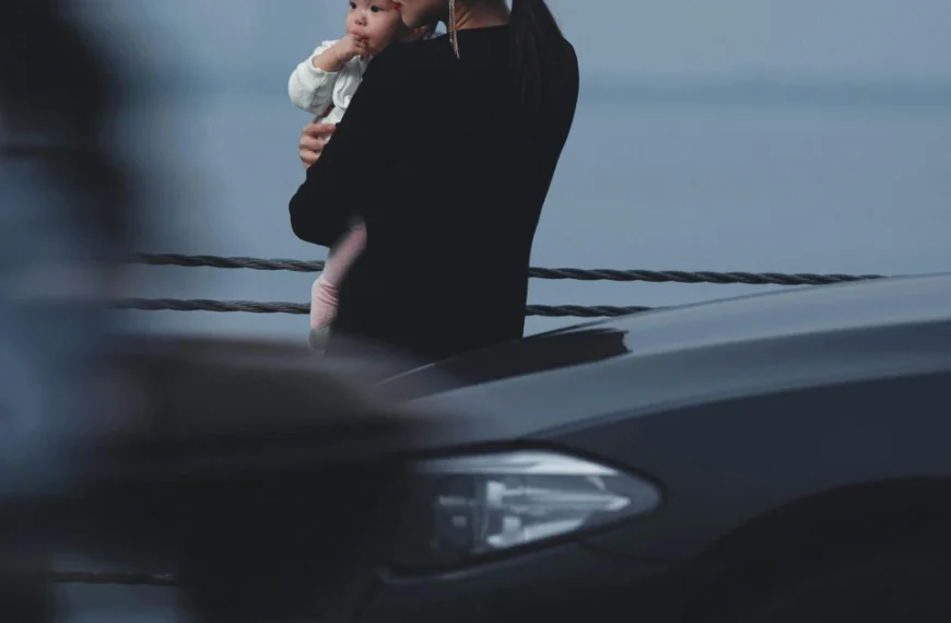 A Mother and her child behind a Sedan