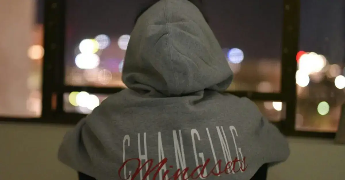 A guy with a grey Hoddie with the writing "Changing Mindsets"