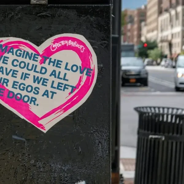 Garbage Can with a sticker on that says "Imagine the Love we could al have if we left our Egos at the Door"