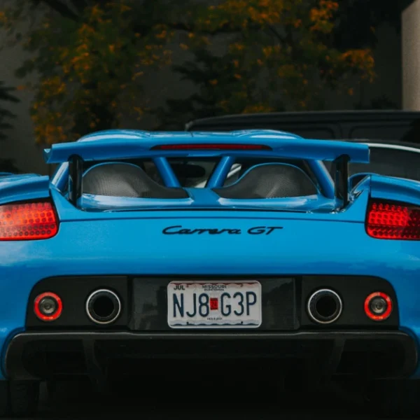 The back of a babyblue Porsche Carrera GT
