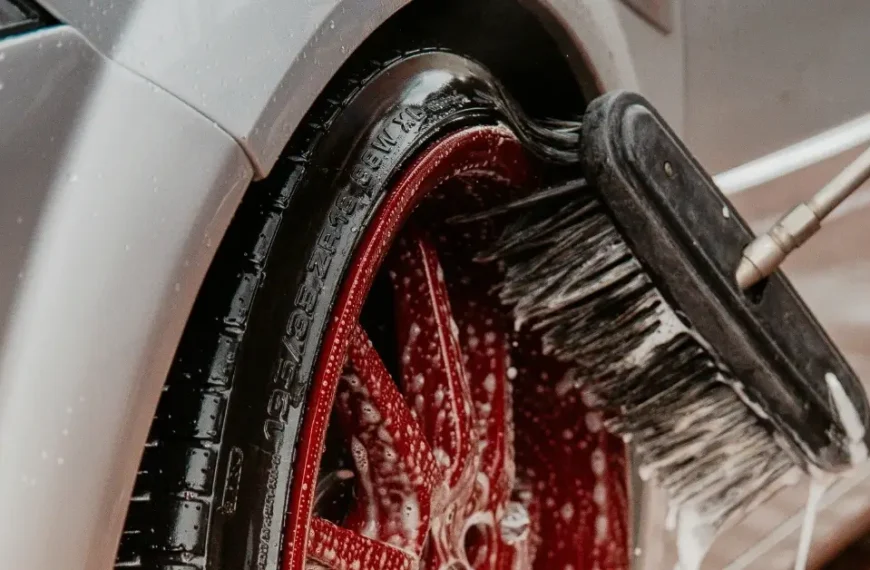 Red Car Rim get brushed with a Car wash Brush