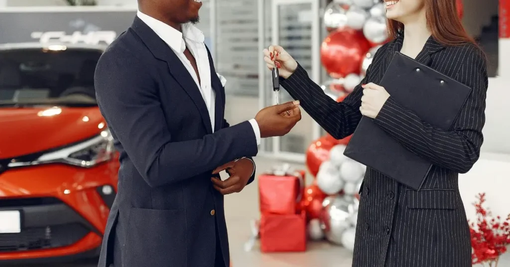 Handover of Car Keys in front of a red car