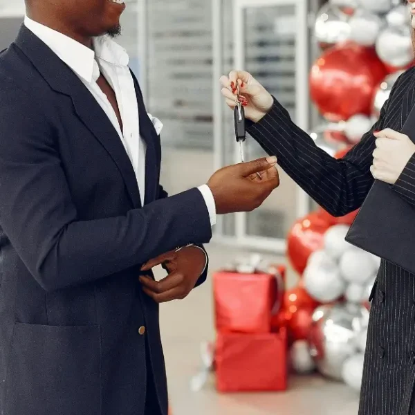 Handover of Car Keys in front of a red car