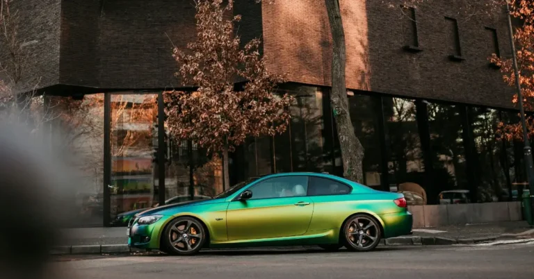 A Rainbowcolor wrapped BMW on the side of a street
