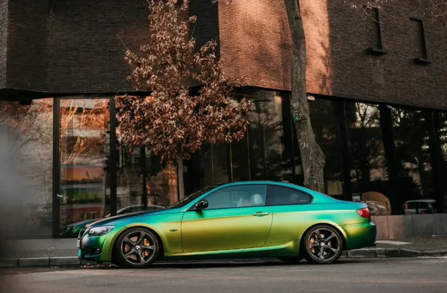 A Rainbowcolor wrapped BMW on the side of a street