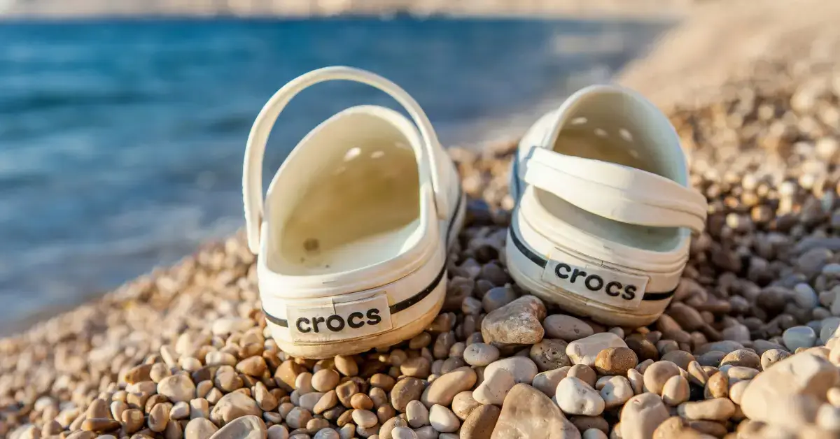 Two white Crocs standing on a Sandbeach
