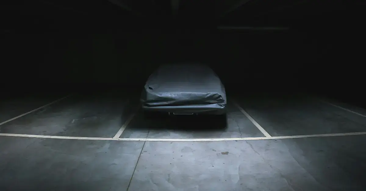 Car underneatch a Car Cover standing in a Park Garage